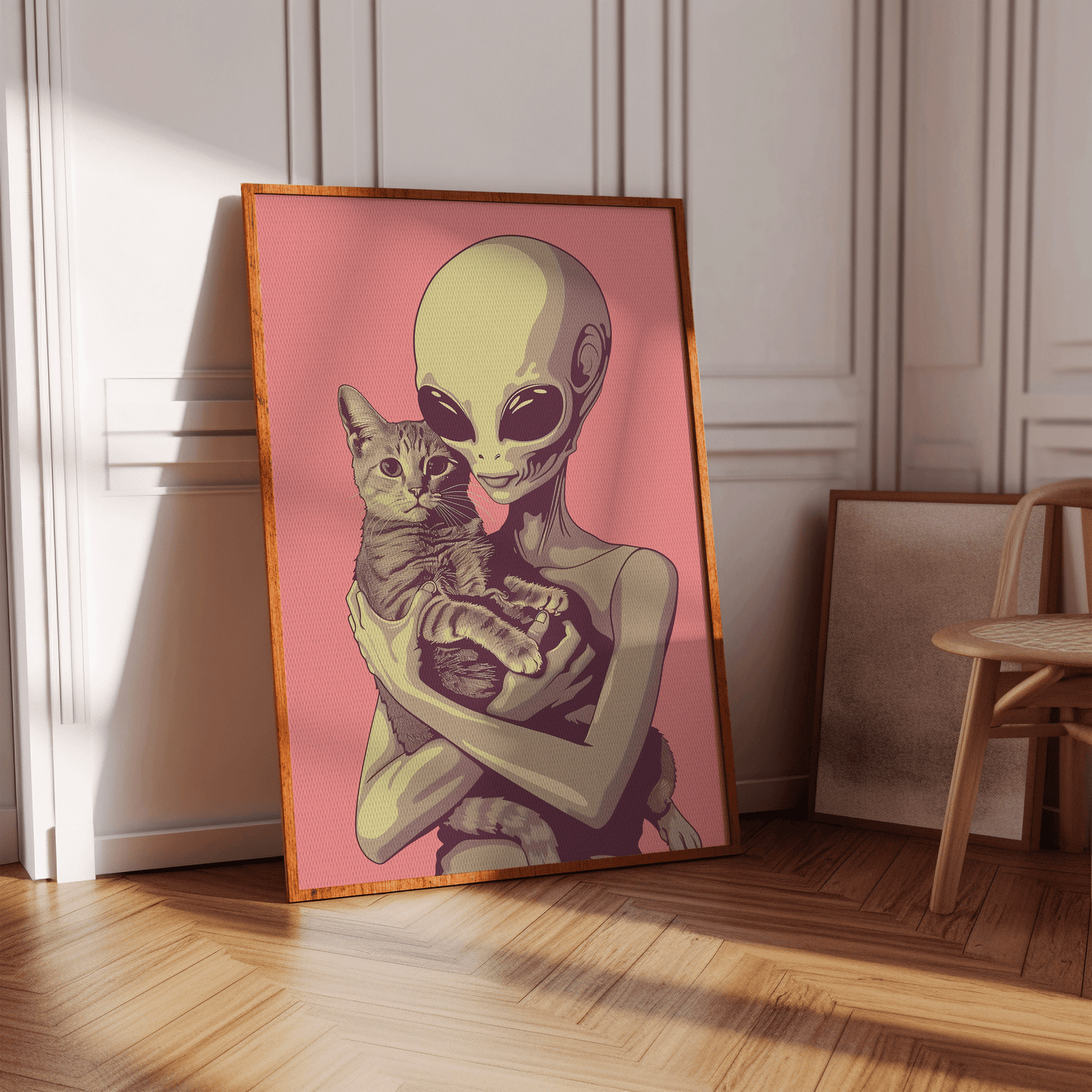Framed poster of a retro alien cradling a cute tabby cat with a pink background, in an empty hallway.