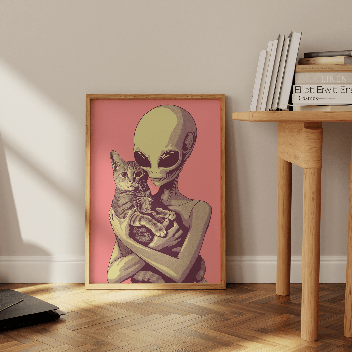 Paw Prints framed poster of a retro alien cradling a tabby cat in a pink background, leaning against the office floor.
