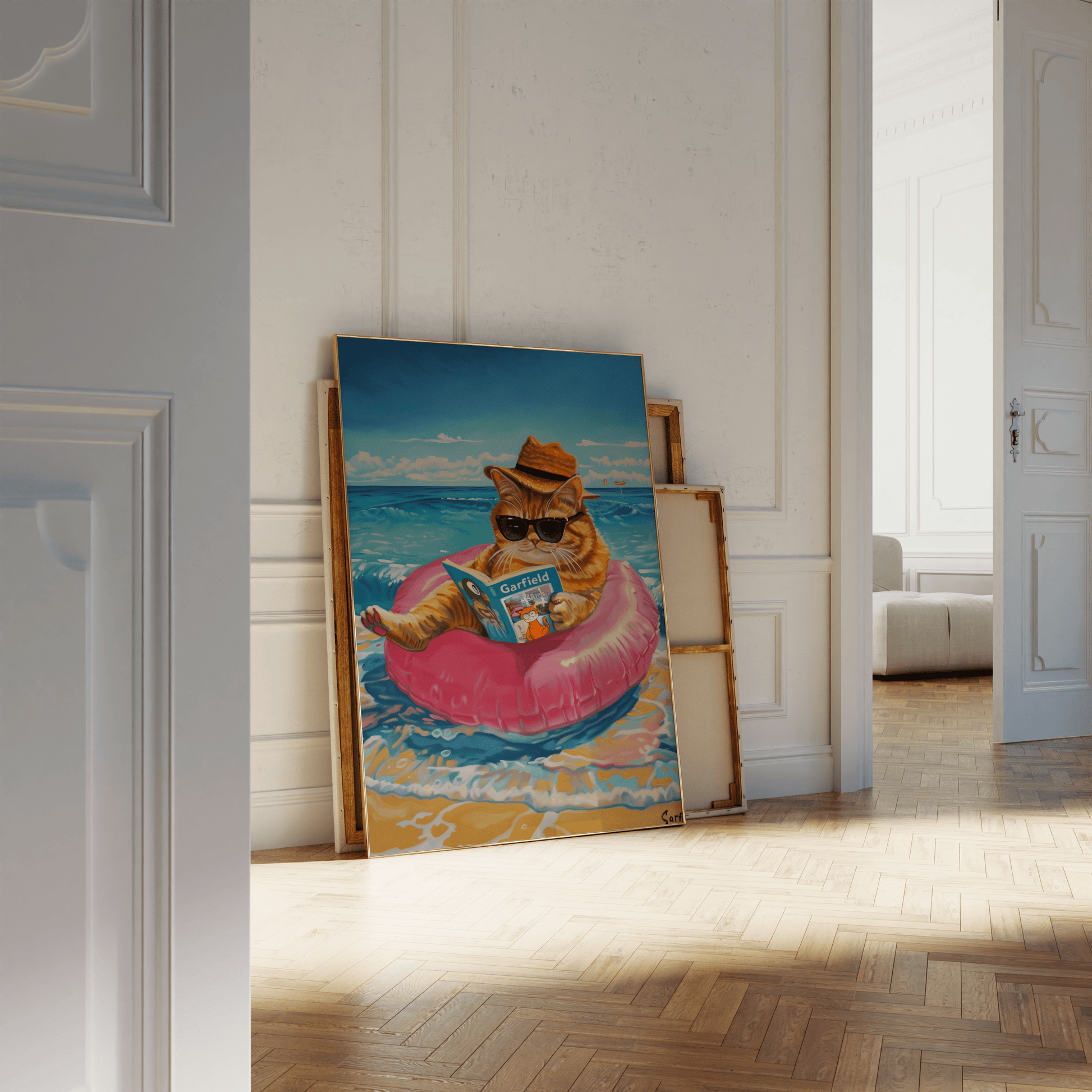 Framed poster of a cat wearing a straw hat reading Garfield, sitting on the beach, leaning against a white bathroom wall