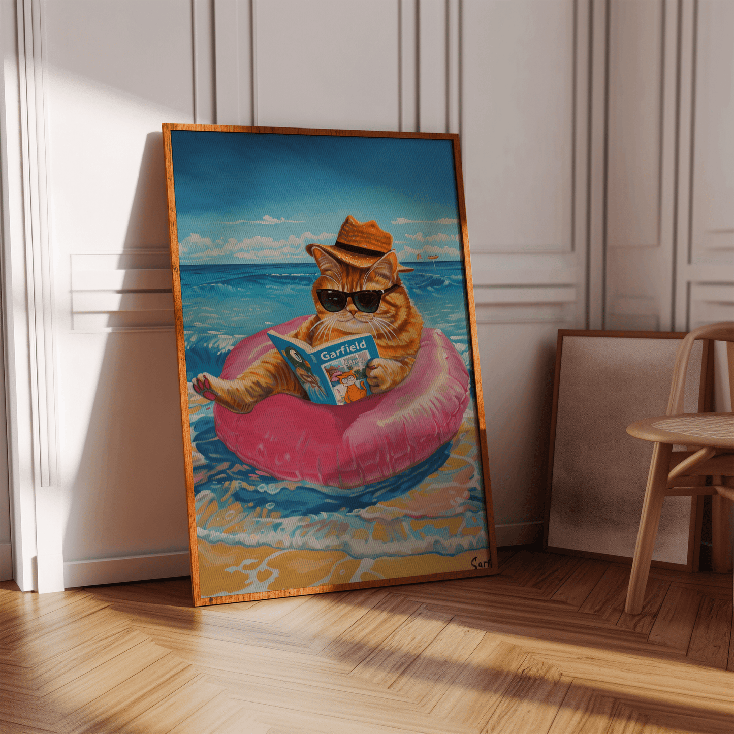 Painting of a cat wearing a straw hat and sunglasses reading Garfield, sitting on a ring at the beach - Paw Prints