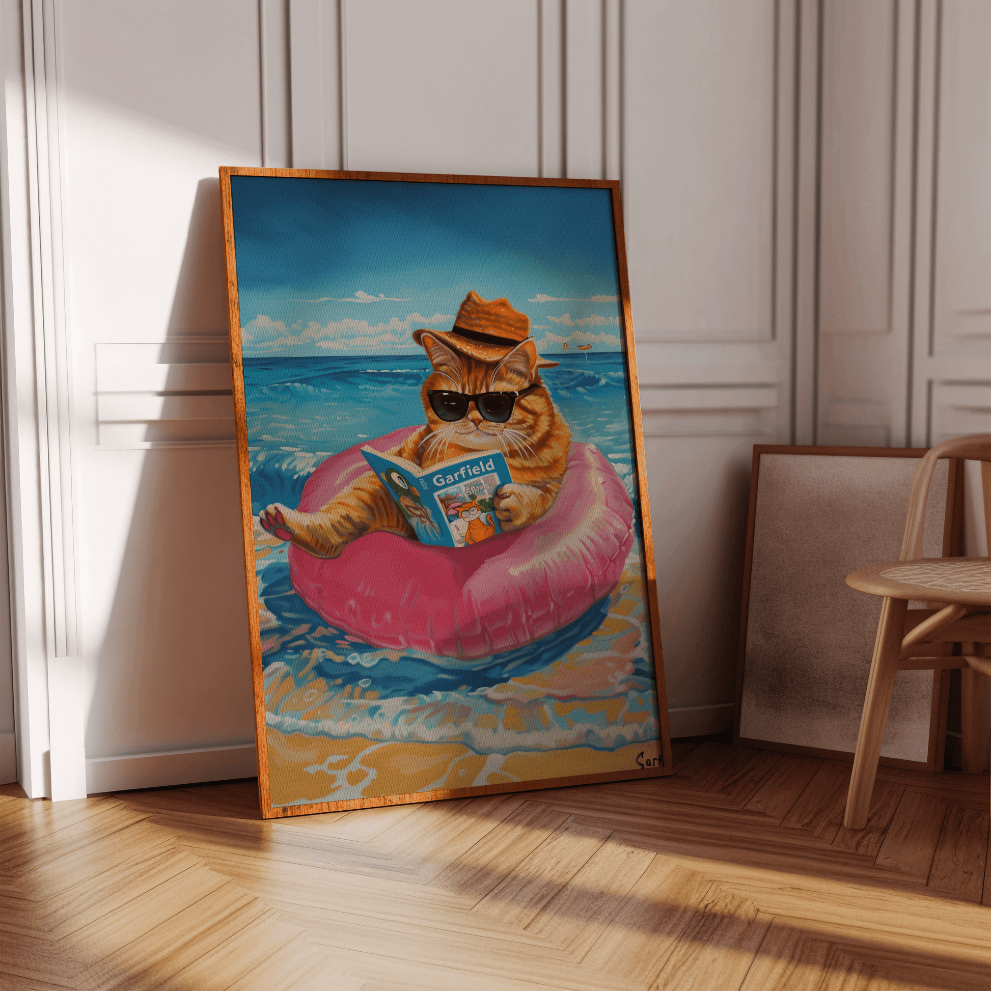 Painting of a cat wearing a straw hat and sunglasses reading Garfield, sitting on a ring at the beach - Paw Prints