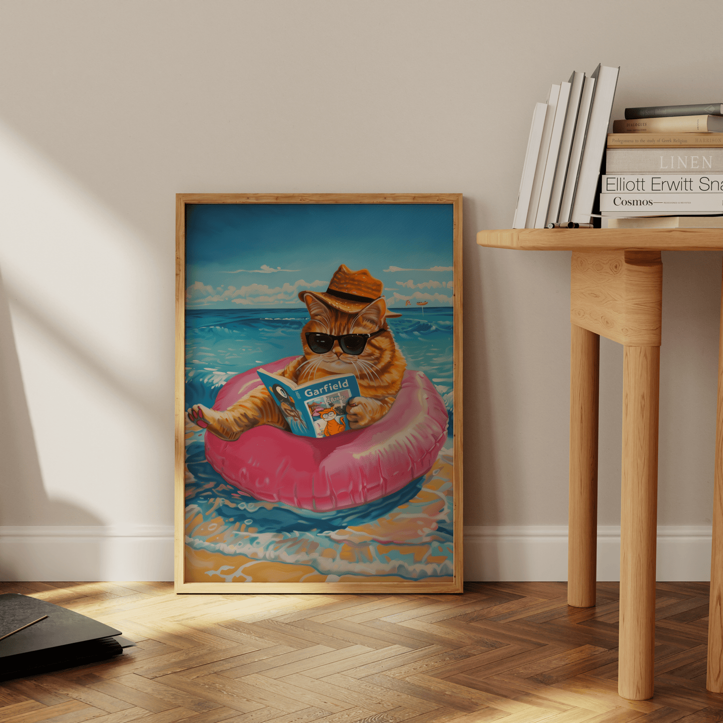 Framed poster of a cat wearing a straw hat reading Garfield, sitting on the beach, leaning against the office wall